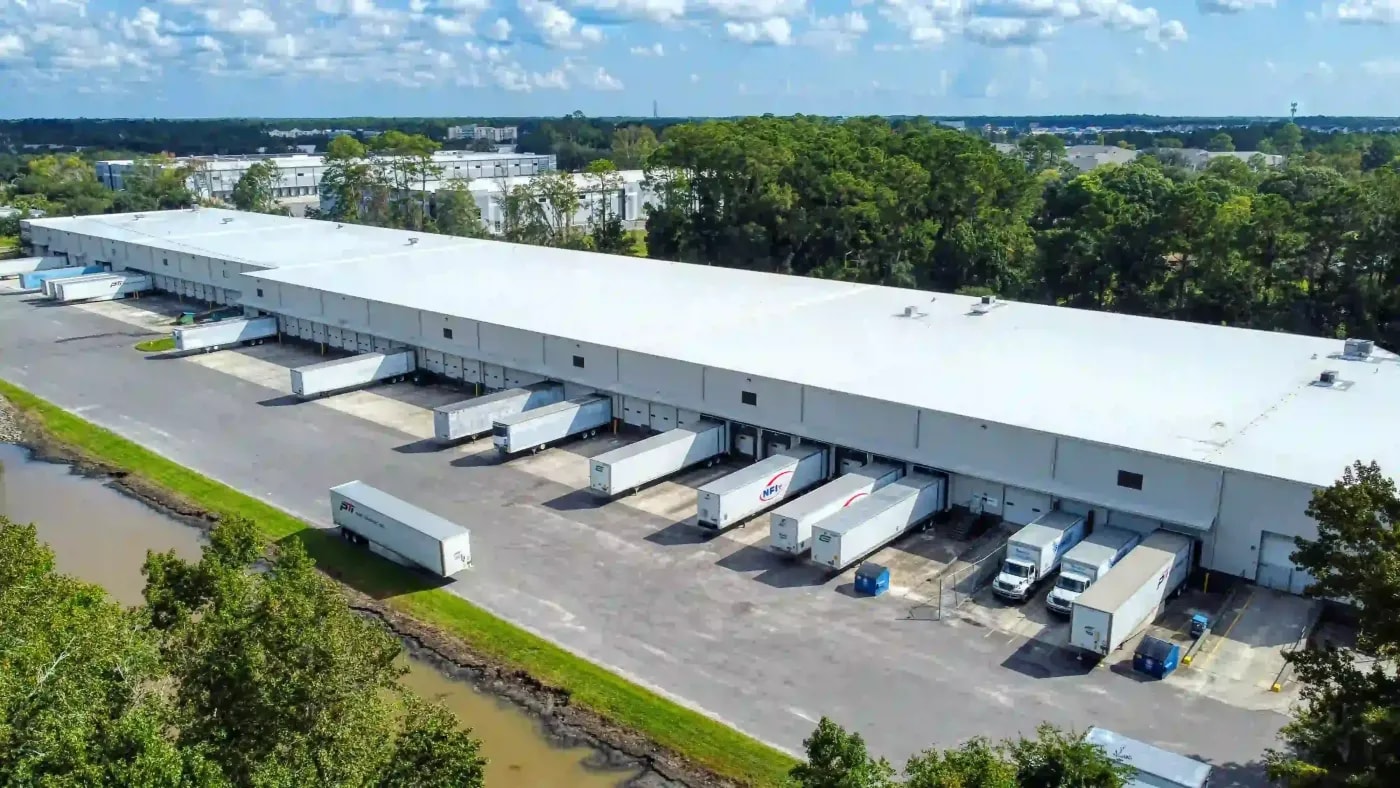 Ground-level drone view of industrial distribution hub with multiple trailer bays and high-throughput freight access