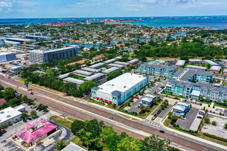 Drone perspective of dense residential development near water in a port-adjacent area with construction activity nearby